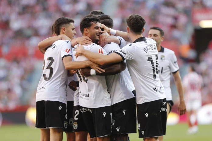 Kevin Appin, fundido en un abrazo con sus compañeros tras anotar en El Molinón