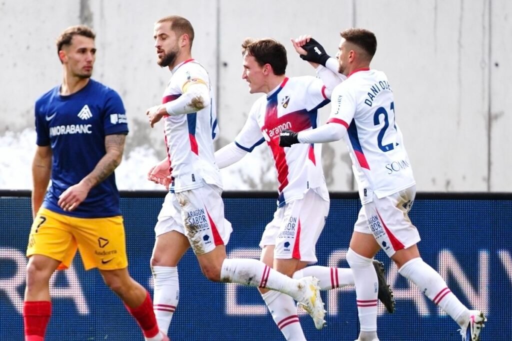Huesca: Con pie y medio en Primera Federación 1 Kortajarena junto a Pulido y Ojeda, celebrando su último gol con el Huesca